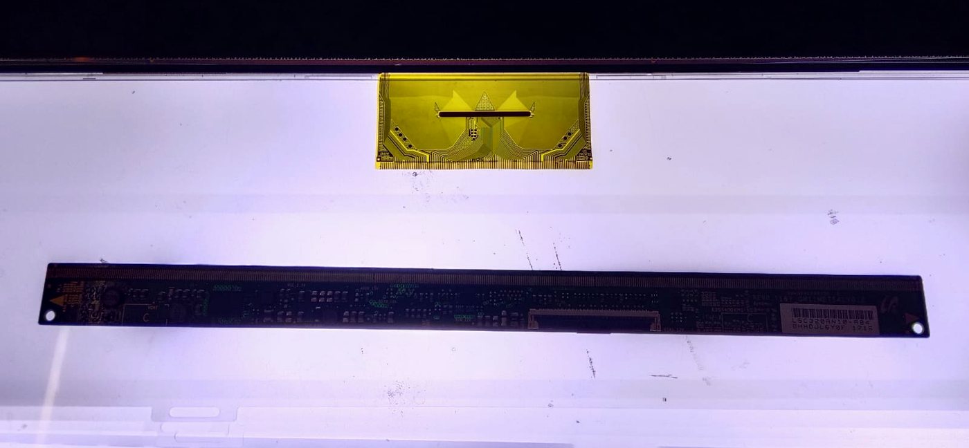 COF chip-on-film ribbon and source board on a TV panel, ready for re-bonding